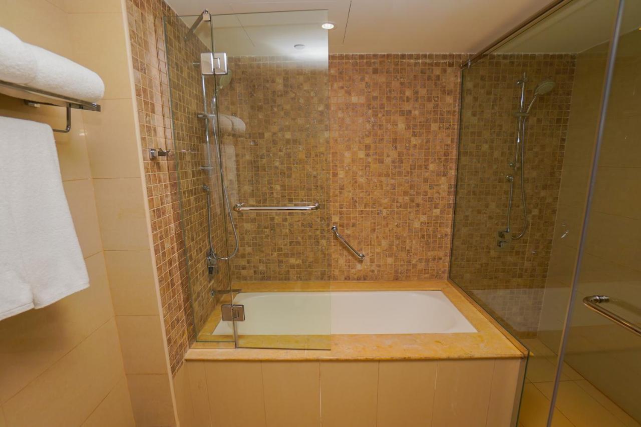 The Grand Lux Hotel Doha Buitenkant foto A bathtub with a shower enclosure