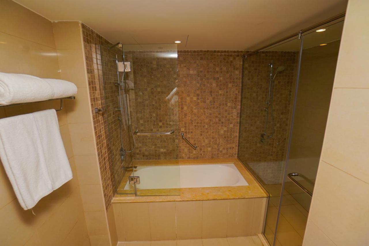The Grand Lux Hotel Doha Buitenkant foto A bathtub with a shower enclosure